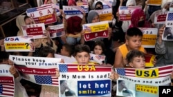 FILE - Afghan refugees hold placards in Islamabad, Pakistan, July 21, 2023. Hundreds of Afghan refugees facing extreme delays in the approval of U.S. visas protested as an American program to help relocate at-risk Afghans fleeing Taliban rule stalled.