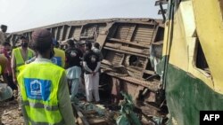 Volunteers search for the victims in the carriages following the derailment of a passenger train in Nawabshah, in the Pakistan's southern Sindh province, Aug. 6, 2023. 