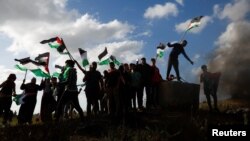 Warga Palestina melakukan aksi protes menentang diadakannya pawai bendera tahunan oleh warga Yahudi pada perayaan “Hari Yerusalem,” yang menandai penaklukan Israel atas Kota Tua itu 56 tahun lalu, di Jalur Gaza hari Kamis (18/5). 