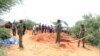 Police officers stand near a cordon at the scene where police are exhuming bodies of victims of Christian cult that has led to death of dozens of followers on the outskirts of Malindi, Kenya, April 25, 2023. 