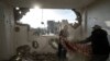 Warga Palestina mengumpulkan barang-barang mereka dari rumah mereka yang rusak pasca serangan udara Israel di Rafah, Jalur Gaza selatan, 27 Januari 2024. (Foto: AP)