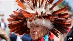 A supporter waits for President Joe Biden to speak and sign a proclamation designating the Baaj Nwaavjo I'Tah Kukveni National Monument at the Red Butte Airfield, Aug. 8, 2023, in Tusayan, Arizona.