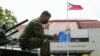Seorang tentara menggunakan ponsel cerdasnya di atas merian lapis baja di Kota Quezon, Filipina, pada 23 Mei 2022. (Foto: AP)