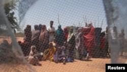 FILE - Somali refugees are seen through a discarded mosquito net as they gather in the new arrivals area of the Dadaab refugee camp near the Kenya-Somalia border, in Garissa county, Kenya, Jan. 17, 2023. A new program allows refugees the chance to relocate in the U.S.