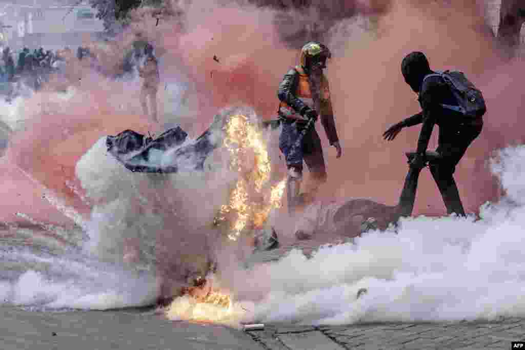 A tear gas canister explodes as protesters try to help injured people outside the Kenya Parliament during a nationwide strike to protest against tax hikes and the Finance Bill 2024 in downtown Nairobi, June 25, 2024. 