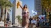 Një grua mban fotografinë e një fëmije të rrëmbyer gjatë sulmit të Hamasit në Israel (Tel Aviv, 25 tetor 2023)