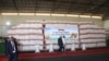 People walk past grain donated by Russia to Zimbabwe, in Harare, March 20, 2024. 