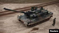 FILE - Tentara Polandia terlihat di dekat tank K2, yang dikirim dalam gelombang pertama senjata dari Korea Selatan selama latihan militer di lapangan militer Wierzbiny dekat Orzysz, Polandia, 30 Maret 2023. (REUTERS/Kacper Pempel)