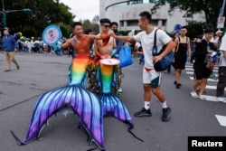 Para peserta saling menyapa dalam pawai Pride Taiwan di Taipei, Taiwan, Sabtu, 28 Oktober 2023. (Foto: Ann Wang/Reuters)