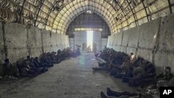 Sekitar lebih dari 100 tahanan perang Rusia yang ditangkap oleh unit khusus Layanan Keamanan Ukraina berkumpul di dalam sebuah tempat di wilayah Kursk, Rusia, pada 14 Agustus 2024. (Foto: Ukrainian Security Service Press Office via AP)