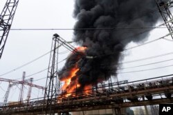 Api dan asap mengepul dari kobaran api di fasilitas listrik setelah serangan Rusia di Kharkiv, Ukraina, 22 Maret 2024. (Foto: AP)