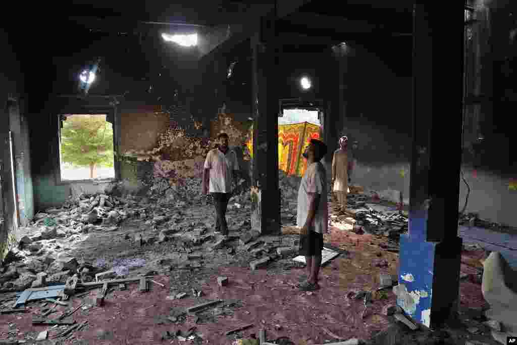 Christians look at a church vandalized by an angry Muslim mob in Pakistan on Aug. 17, 2023.