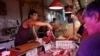 FILE - A pork vendor attends to a customer at a morning market in Beijing, China August 9, 2023.