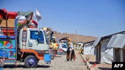 Afghan refugees walk through a registration center upon their arrival from Pakistan in Takhta Pul district of Kandahar province on May 22, 2024. 