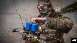 Seorang tentara Ukraina mempersiapkan drone FPV di garis depan pertempuran di dekat Avdiivka, wilayah Donestk, pada 22 Maret 2024. (Foto: AP/Efrem Lukatsky, File)
