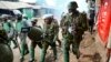 FILE - Riot policemen walk back during clashes with protesters in the Kibera area of Nairobi, Kenya, on July 19, 2023. Kenya has offered to lead an international police force aimed at combating Haiti's gang violence. 