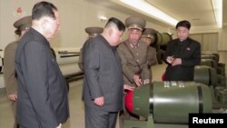 Tangkapan layar menunjukkan pemimpin Korea Utara Kim Jong Un sedang memeriksa hulu ledak nuklir di lokasi yang dirahasiakan dalam video yang dirilis oleh KCNA pada 28 Maret 2023. (KRT/Handout via Reuters)