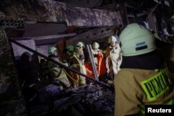 Petugas pemadam kebakaran membawa kantong jenazah korban kebakaran terjadi di stasiun penyimpanan bahan bakar yang dioperasikan oleh Pertamina, di Plumpang, Jakarta, 3 Maret 2023. (REUTERS/Willy Kurniawan)