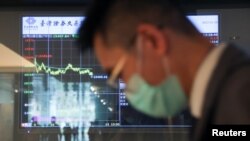 一名男子站在台灣證券交易所的電子螢幕前。 （2023年3月20日）