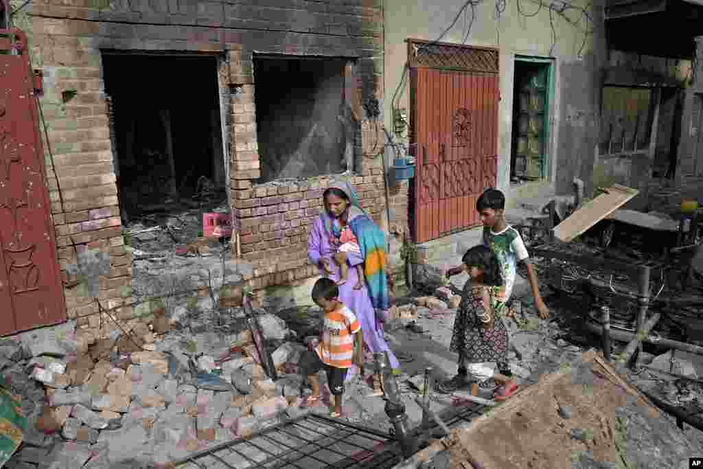Christians walk through the rubble of homes vandalized by an angry Muslim mob in Pakistan on Aug. 17, 2023.