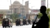 FILE - Siluet seorang polisi saat berjaga sementara pasukan paramiliter berpatroli sebagai tindakan pengamanan, menyusul kunjungan Presiden Iran Ebrahim Raisi, di Karachi, 23 April 2024.
