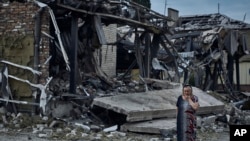 Seorang perempuan tampak berada di lokasi dari sebuah bangunan yang rusak akibat serangan rudal Rusia di Pokrovsk, wilayah Donetsk, Ukraina, pada 9 Agustus 2023. (Foto: AP/Libkos)
