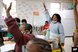 Zeniyha Howard, 10, of Decatur, Ga., raises their hand during a math lesson at the Kilombo Academic and Cultural Institute, March 28, 2023, in Decatur, Ga.