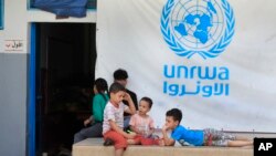 Anak-anak Palestina yang melarikan diri bersama orang tuanya dari rumah mereka di kamp pengungsi Palestina di Ein el-Hilweh, berkumpul di halaman belakang sekolah UNRWA, di Sidon, Lebanon, 12 September 2023. (Foto: AP)