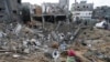 Beberapa warga Palestina memeriksa kehancuran setelah serangan udara Israel di sebuah bangunan permukiman di kota Deir al Balah, Jalur Gaza, 14 Januari 2024.