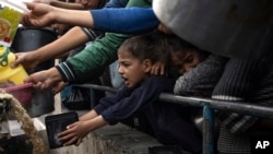 Warga Palestina, termasuk anak-anak, mengantre untuk mendapatkan makanan di Rafah, Jalur Gaza, pada 21 Desember 2023. (Foto: AP/Fatima Shbair)