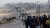 FILE - Warga Palestina, yang mengungsi akibat serangan militer Israel di Gaza selatan, berusaha untuk kembali ke rumah mereka di Gaza utara melalui pos pemeriksaan Israel, seperti yang terlihat dari Jalur Gaza tengah, 15 April 2024.