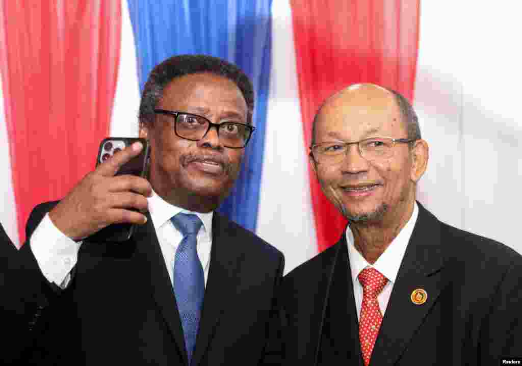 Manm Konsey Prezidansyel Tranzisyon an Fritz Alphonse Jean ak Leslie Voltaire poze pou yon foto apre seremoni enstalasyon konsey la nan Potoprens, 25 Avril, 2024.