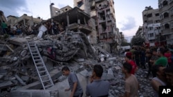 Palestinyen yo chache moun ki blese nan dekonb yon bilding rezidansyel ki detwi pandan yon atak ayeryen Israelyen, Madi 10 Oktob, 2023.