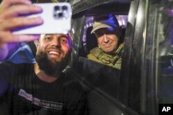 FILE - Yevgeny Prigozhin, owner of the Wagner Group military company, right, poses for a photo with a civilian after taking over the Southern Military District in Rostov-on-Don, Russia, on June 24, 2023.