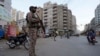 FILE - Tentara paramiliter berjaga di sepanjang pinggir jalan untuk memastikan keamanan di Karachi, Pakistan, Selasa, 9 April 2024. (AP/Fareed Khan)