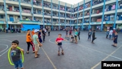 Anak-anak Palestina, yang meninggalkan rumah mereka akibat serangan Israel, bermain di sekolah yang dikelola PBB, di Kota Gaza, 12 Oktober 2023. (REUTERS/Arafat Barbakh)