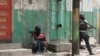 FILE - Police officers take cover during an anti-gang operation in Port-au-Prince, Haiti, April 25, 2023. Two journalists have been killed in Haiti in the past two weeks as gang violence has gripped Port-au-Prince and surrounding areas.