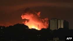Api dan asap tampak mengepul di atas gedung-gedung di Gaza ketika serangan udara Israel menghantam wilayah tersebut pada 13 Oktober 2023. (Foto: AFP/Mahmud Hams)