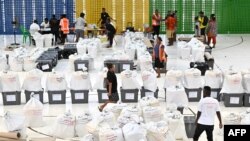 Petugas pemilu menyiapkan kotak suara sebelum memulai penghitungan suara di Honiara, ibu kota Solomon, 18 April 2024. (Saeed KHAN/AFP)