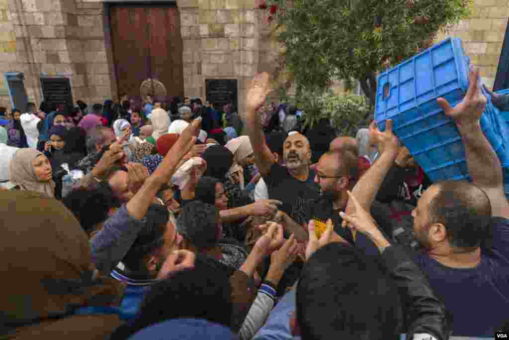 With Al-Azhar Mosque's charity iftar at capacity, hundreds gather outside for free juice and dates to break their 14-hour fast, in Cairo, March 28, 2023. (Hamada Elrasam/VOA)