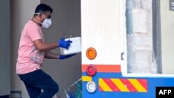 A health worker carries a box of samples to a medical research mobile testing facility in Kozhikode, Kerala state, India, Sept. 15, 2023. India has curbed public gatherings and shut some schools in the state after two people died of the Nipah virus.