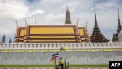 Seorang pendukung kerajaan mengendarai sepedanya yang berhiaskan bendera melewati Grand Palace pada peringatan 70 tahun Raja Thailand Maha Vajiralongkorn di Bangkok pada 28 Juli 2022. (Foto: AFP)