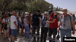 Li Atînayê ev jina geştîyar jiber pêla germê nexweş ket. 12ê Hezîranê, 2024.