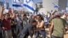 An Israeli police officer scuffles with protesters as they try to block a main road to protest plans by Prime Minister Benjamin Netanyahu's new government to overhaul the judicial system, in Tel Aviv, Israel, March 1, 2023.