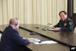 Russian President Vladimir Putin, left, speaks to Gen. Zhang Youxia, vice chairman of China's Central Military Commission, during a meeting at the Novo-Ogaryovo residence outside Moscow, Russia, Nov. 8, 2023.