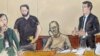 O antigo ministro das Finanças de Moçambique, Manuel Chang, sentado ao centro, ouve o processo judicial através de um intérprete, à esquerda, enquanto o seu advogado Adam Ford, à direita, se dirige ao juiz