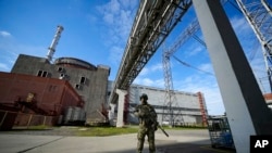 FILE - A Russian serviceman guards the Zaporizhzhia Nuclear Power Station in southeastern Ukraine, May 1, 2022. Power was restored at the plant Saturday after it was lost Friday, averting a "nuclear catastrophe," said Ukraine's energy ministry.
