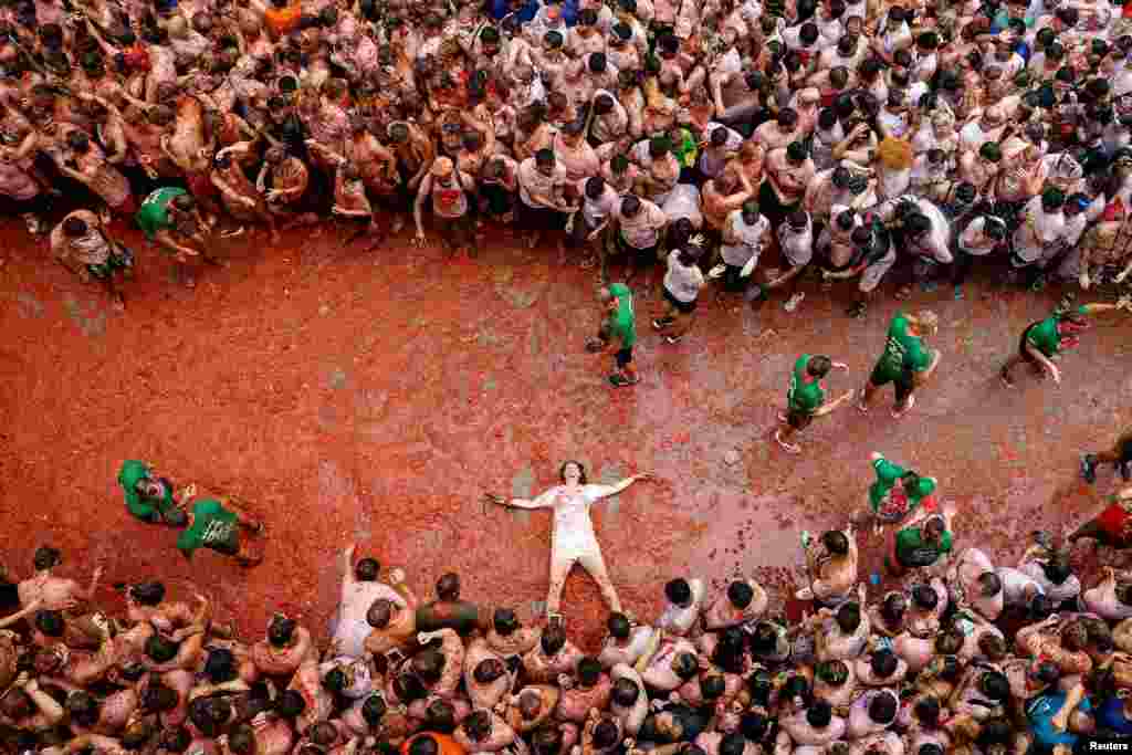 Participante deitado sobre polpa de tomate durante o festival “La Tomatina” em Bunol, perto de Valência, Espanha, a 28 de agosto de 2024. 