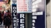 FILE - People walk near a currency exchange point, in La Paz, Bolivia, March 6, 2023. 