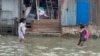Anak-anak sedang bermain saat banjir rob melanda kawasan Kecamatan Medan Belawan, Kota Medan, Sumatra Utara. Jumat 19 Mei 2023